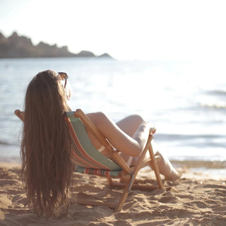 Mujer tumbada al sol junto al agua para la absorción de Vitamina D3