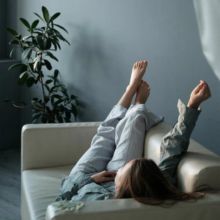 Mujer tumbada en el sofá, estirándose, relajándose.