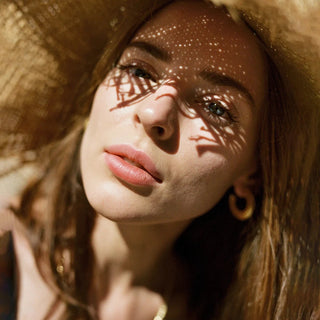 Rostro de mujer con sombrero para el sol, bajo el sol.