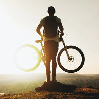 Hombre con bicicleta en la montaña
