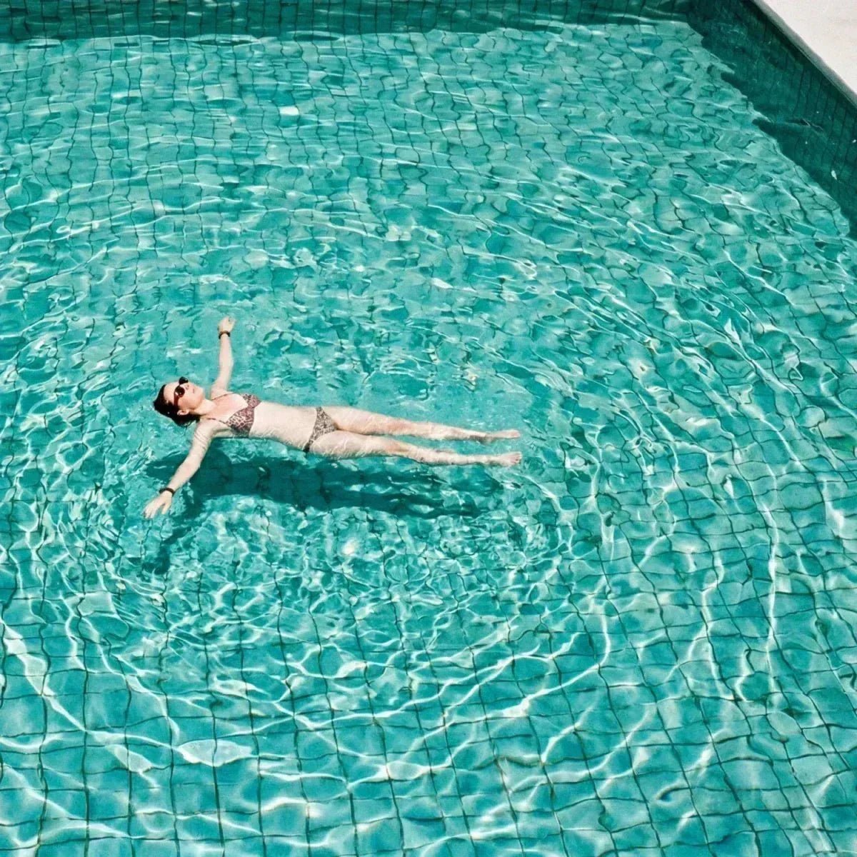 Eine Frau liegt entspannt auf dem Wasser im Pool