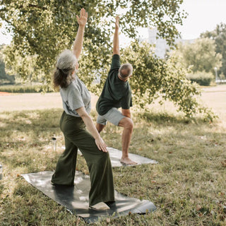 2 personas haciendo yoga al aire libre para relajarse y sentirse bien