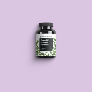 Una botella de vitamina C sobre fondo violeta, destacando elementos naturales.