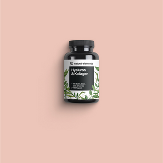 Una botella de vitamina C con hojas verdes sobre un fondo rosa, destacando los elementos naturales.