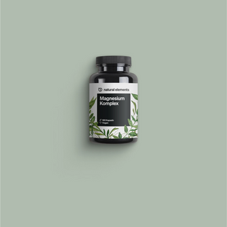 Una botella de Vitamina C con hojas verdes sobre un fondo.